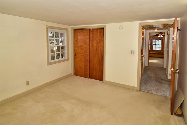 unfurnished bedroom with radiator heating unit, a closet, baseboards, and carpet flooring