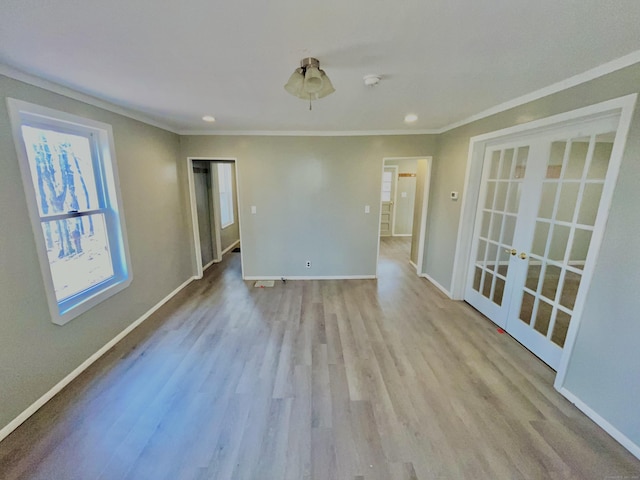 spare room featuring baseboards, ornamental molding, wood finished floors, and french doors