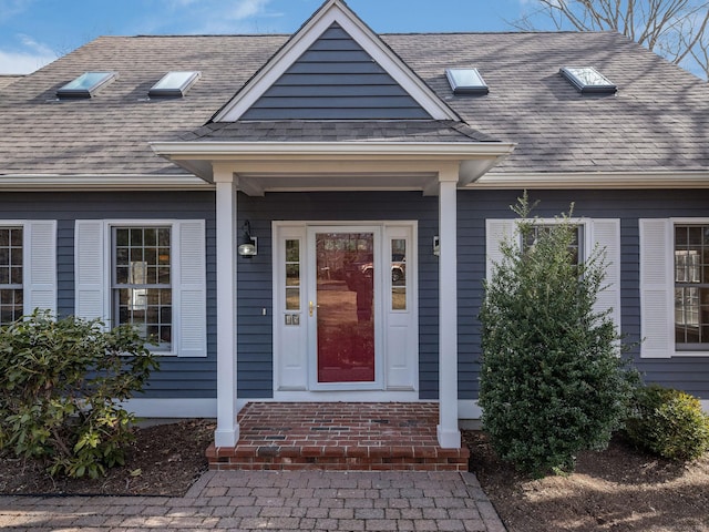 property entrance featuring a shingled roof