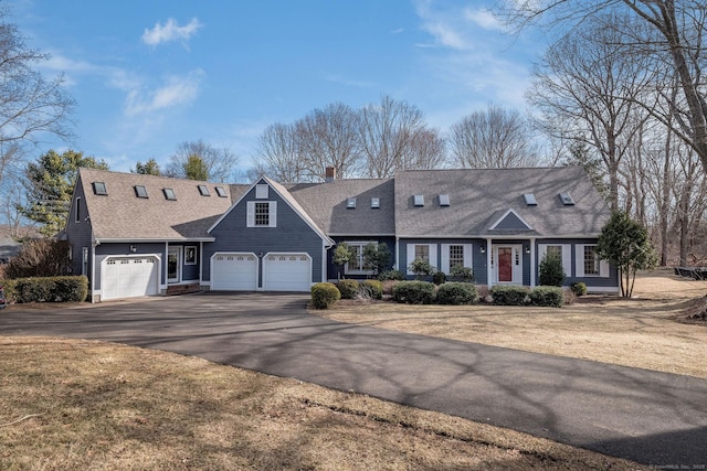 view of front facade with driveway, a front lawn, and roof with shingles