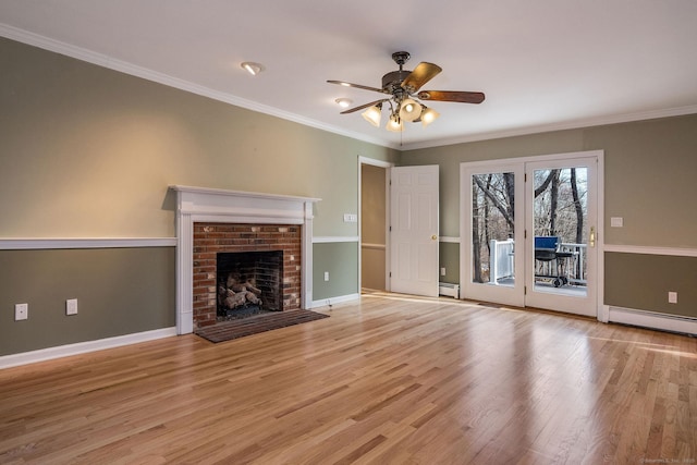 unfurnished living room with baseboard heating, a brick fireplace, wood finished floors, and crown molding