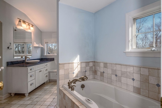 full bath featuring vanity, a garden tub, tile patterned floors, and vaulted ceiling