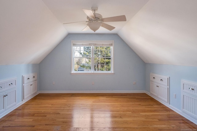 additional living space with light wood finished floors, baseboards, and lofted ceiling