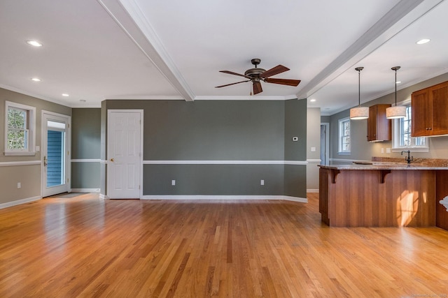 unfurnished living room featuring a ceiling fan, baseboards, recessed lighting, ornamental molding, and light wood-type flooring