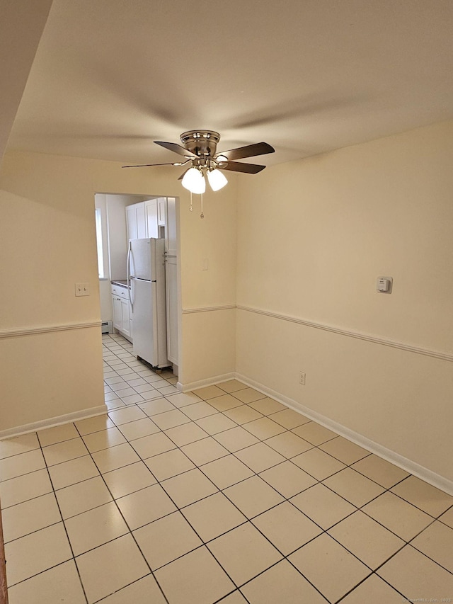 unfurnished room with light tile patterned floors, a ceiling fan, and baseboards