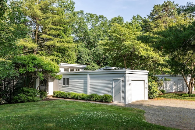 view of outdoor structure featuring gravel driveway and a garage