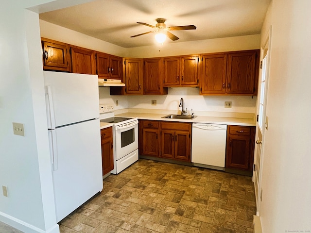 kitchen featuring brown cabinets, under cabinet range hood, a sink, white appliances, and light countertops