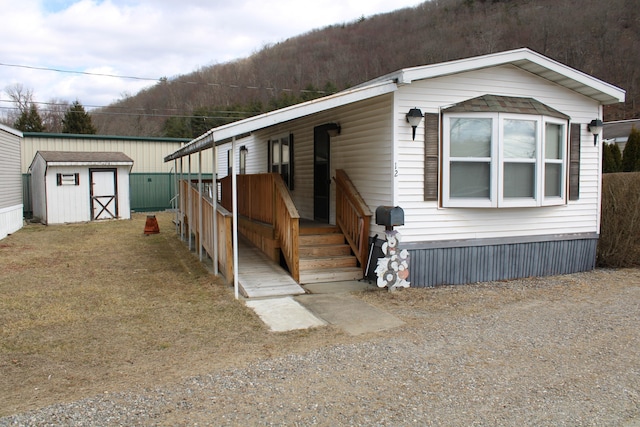 manufactured / mobile home with a storage shed and an outdoor structure