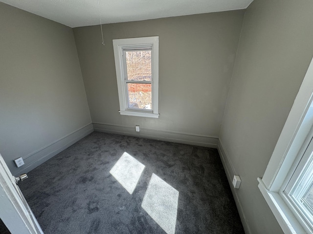 carpeted empty room with baseboards