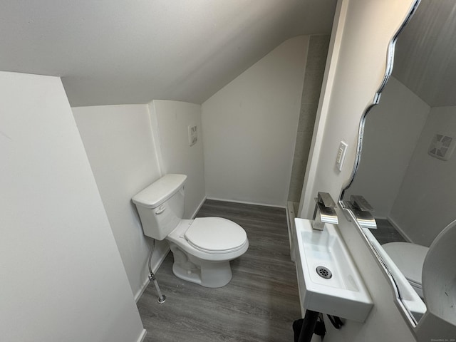 bathroom featuring lofted ceiling, wood finished floors, toilet, and baseboards