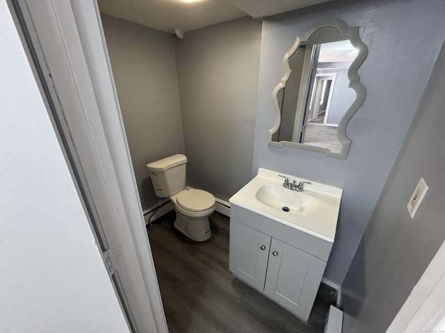 bathroom featuring a baseboard heating unit, vanity, toilet, and wood finished floors