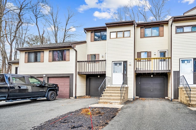 townhome / multi-family property featuring a balcony, driveway, and an attached garage