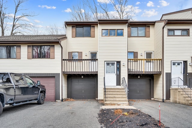 townhome / multi-family property with driveway, a balcony, and a garage