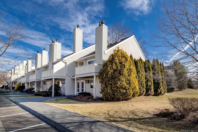 view of side of home featuring a balcony and a chimney