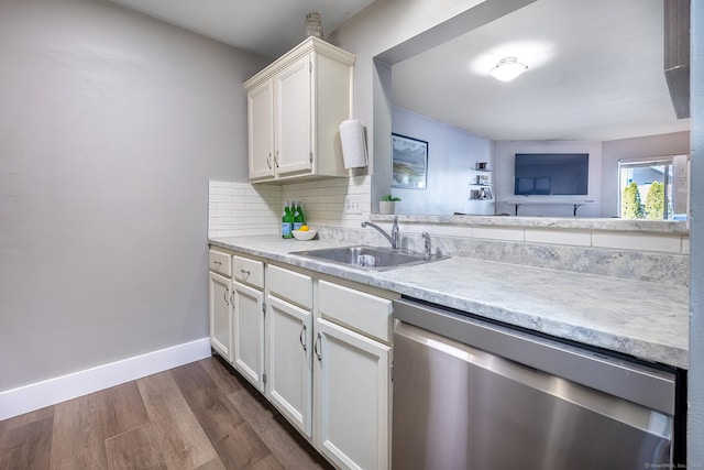 kitchen with a sink, decorative backsplash, light countertops, dark wood-type flooring, and dishwasher