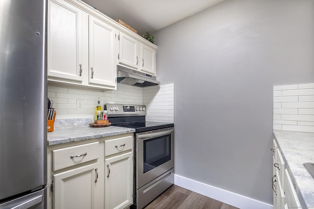 kitchen featuring under cabinet range hood, decorative backsplash, appliances with stainless steel finishes, and baseboards