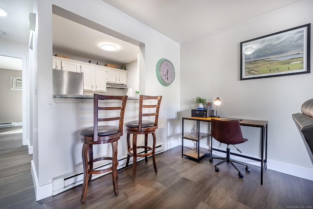 kitchen featuring a baseboard heating unit, dark wood-type flooring, under cabinet range hood, white cabinets, and refrigerator