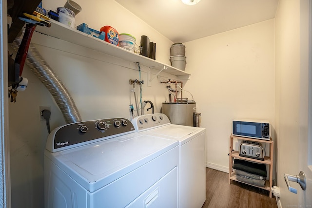 laundry area with laundry area, gas water heater, washer and dryer, and dark wood-type flooring