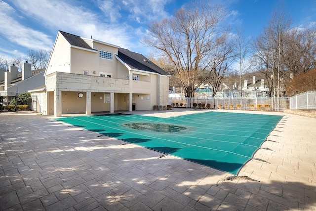 pool with a patio area and fence