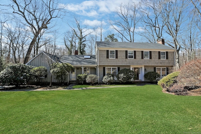 colonial house featuring a front yard and a chimney