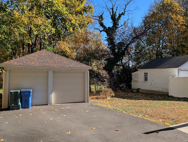 detached garage featuring fence