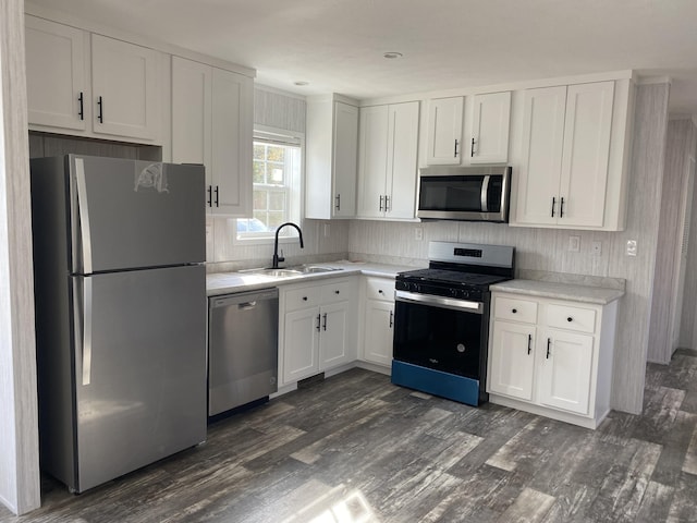 kitchen with dark wood-style floors, stainless steel appliances, light countertops, and white cabinets