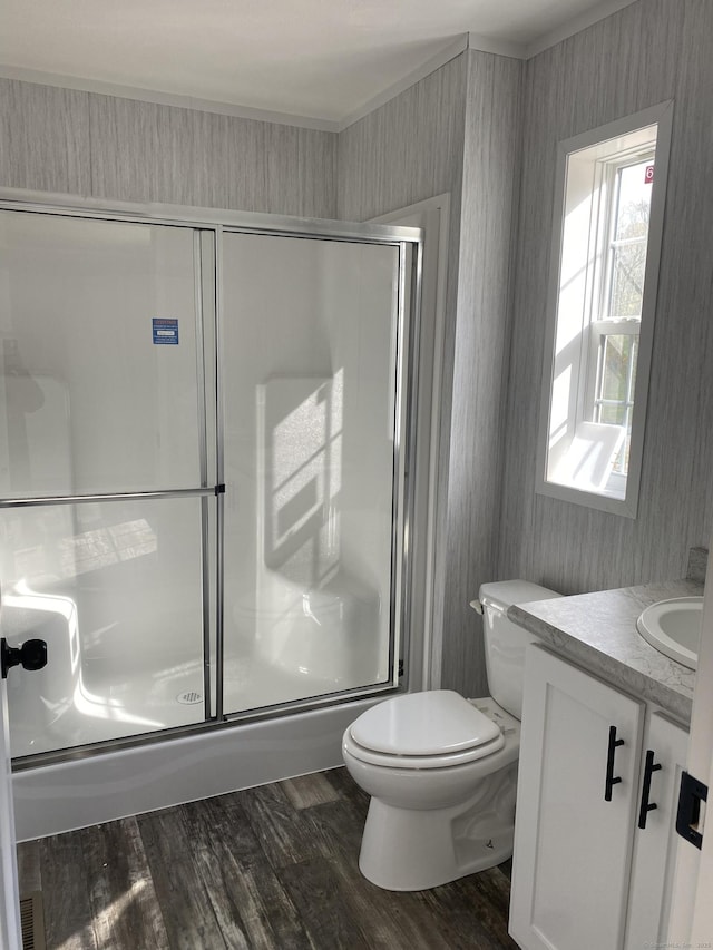 full bath featuring toilet, an enclosed shower, wood finished floors, and vanity