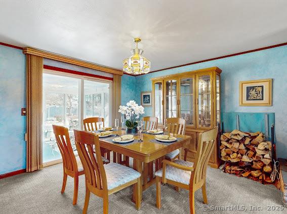 dining room with light colored carpet, baseboards, and ornamental molding