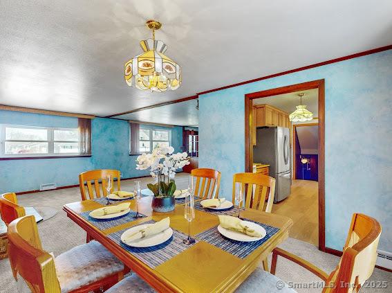 dining space featuring a textured wall and ornamental molding