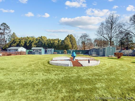 view of yard with an outbuilding, a storage unit, and fence