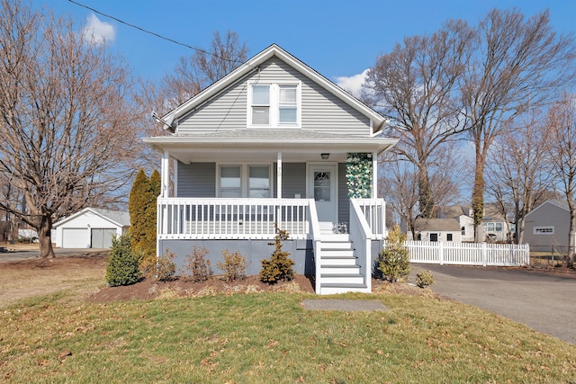 bungalow-style home with a porch, a garage, fence, and a front yard