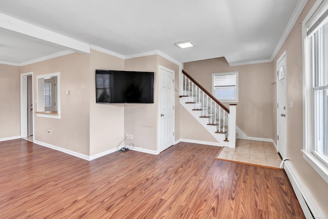 interior space with baseboard heating, ornamental molding, stairway, and wood finished floors