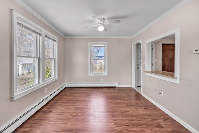 spare room featuring a baseboard heating unit, baseboard heating, a healthy amount of sunlight, and crown molding