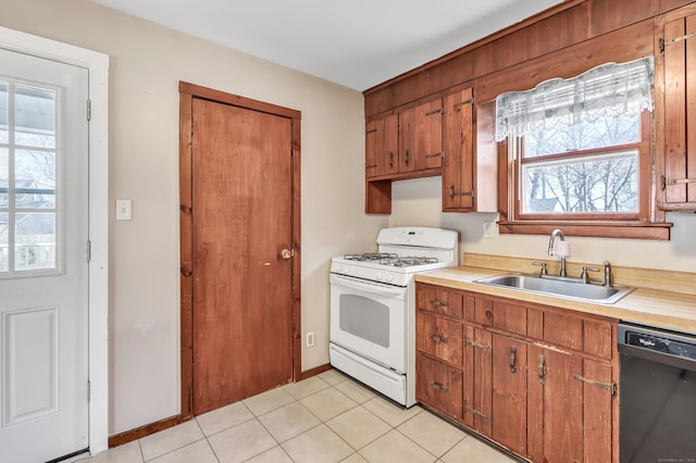 kitchen featuring a sink, black dishwasher, white gas stove, and light countertops