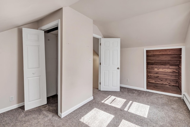 additional living space featuring a baseboard radiator, baseboards, carpet floors, and vaulted ceiling