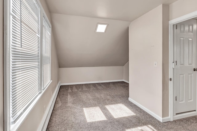 additional living space with plenty of natural light, baseboards, carpet, and vaulted ceiling