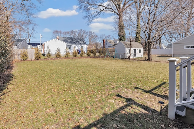 view of yard with a residential view, an outbuilding, and fence