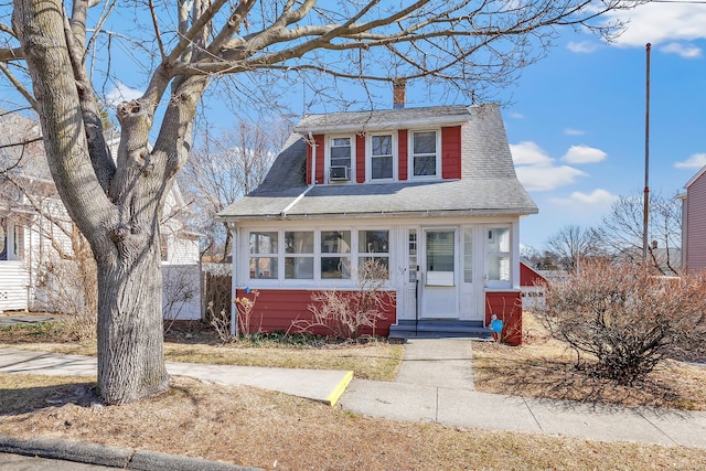 view of front of home featuring roof with shingles, a chimney, and entry steps