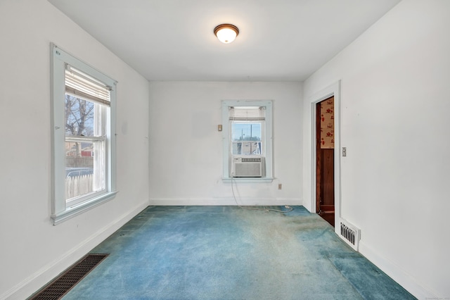 spare room with visible vents, carpet flooring, cooling unit, and baseboards