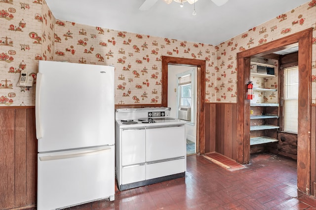 kitchen featuring wainscoting, white appliances, wallpapered walls, and a ceiling fan