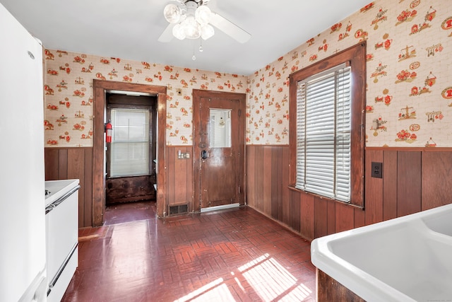 interior space featuring wainscoting, brick patterned floor, and wallpapered walls