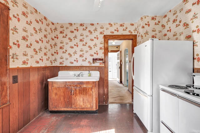 interior space with wainscoting, wallpapered walls, and brick floor