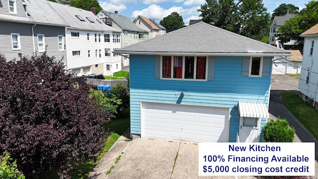 view of front of property featuring an attached garage, driveway, and roof with shingles