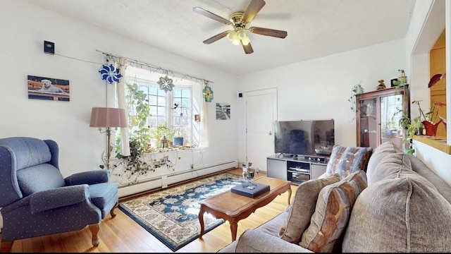 living room with ceiling fan, a baseboard radiator, and wood finished floors