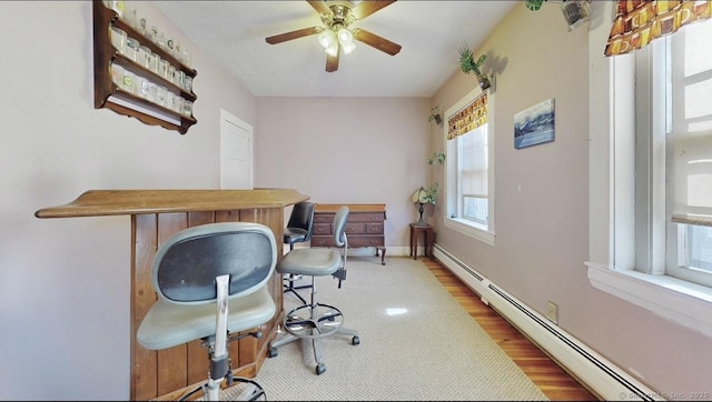 office area with baseboards, baseboard heating, a ceiling fan, and wood finished floors