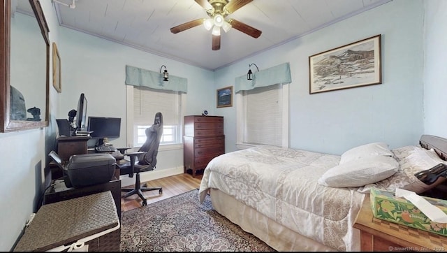 bedroom with ornamental molding, ceiling fan, and wood finished floors