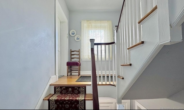 stairs with baseboards and wood finished floors