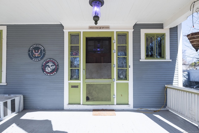 entrance to property featuring a porch and central air condition unit