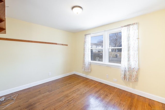 empty room with baseboards and wood finished floors