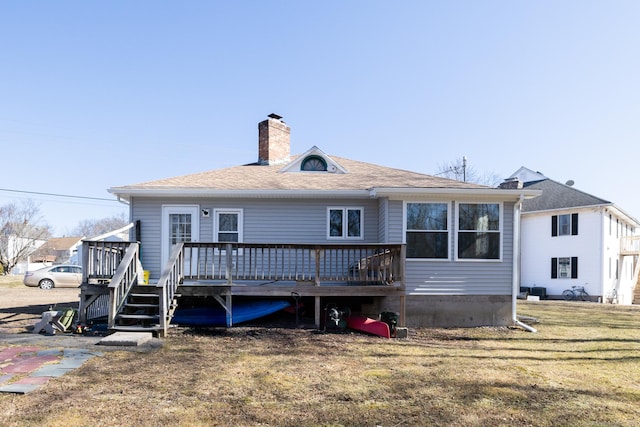 rear view of property featuring a yard, a chimney, and a wooden deck